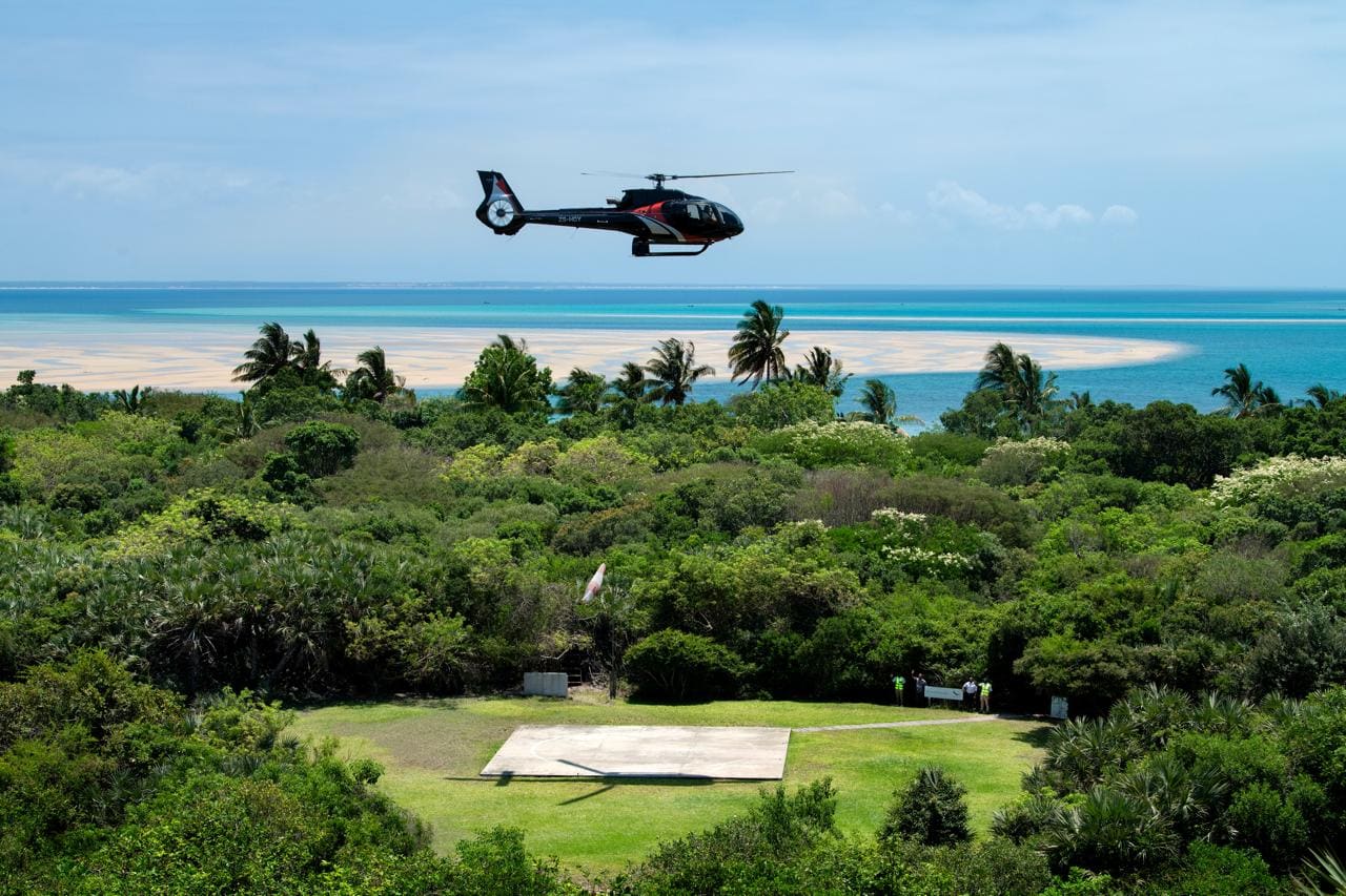 Helicopter flying over an island shoreline